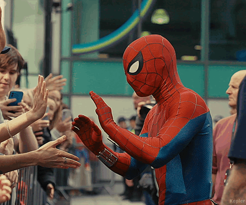 a person in a spiderman costume giving a high five