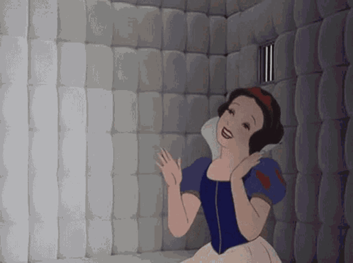 Snow White claps inside a padded gray room.