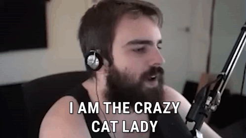 a man with a beard and headphones is sitting in front of a microphone .
