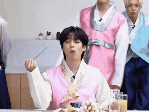 a man in a pink vest is eating something with a spoon
