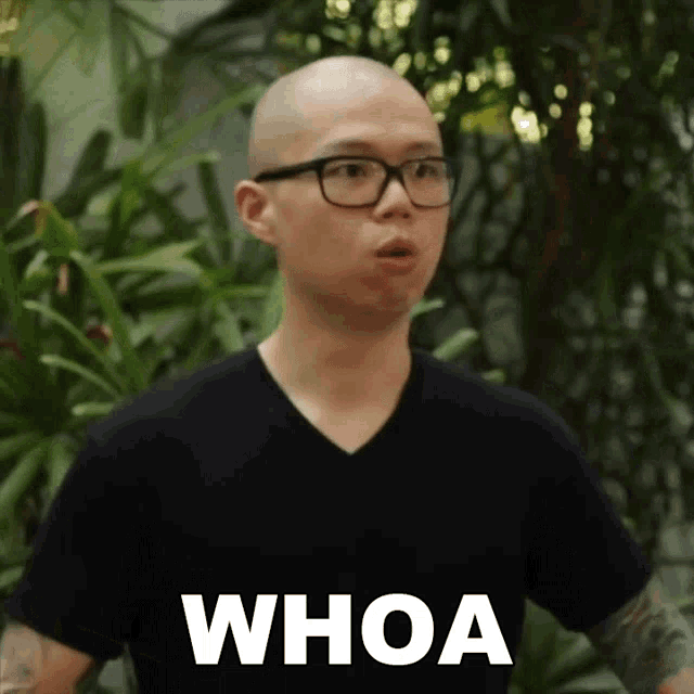 a man wearing glasses and a black shirt with the word whoa on it