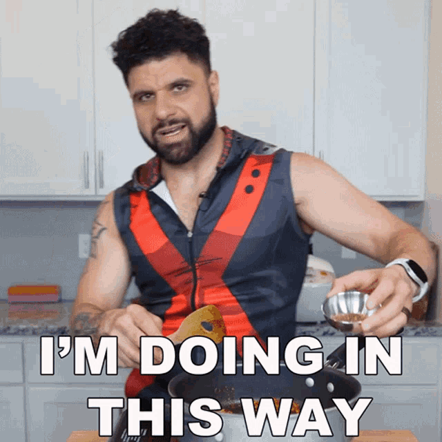 a man with a beard and a red and black vest says i 'm doing in this way
