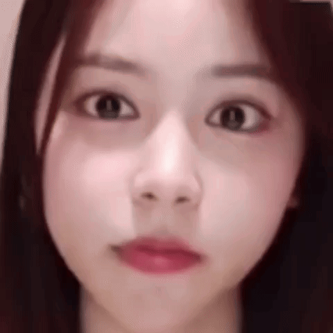 A young woman looks forward with wide, startled eyes.