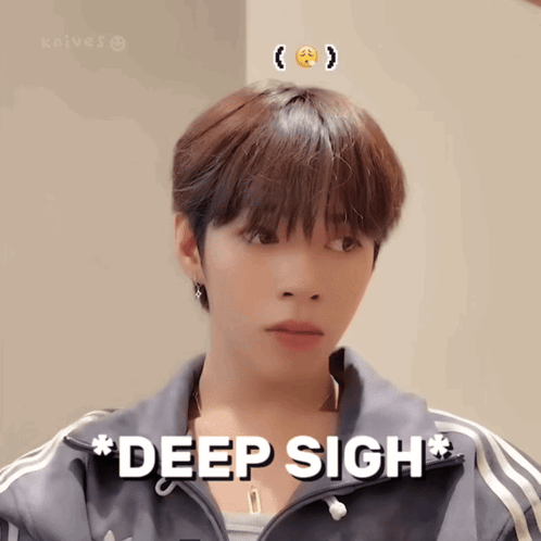 a young man with a smiley face on his head is wearing a jacket that says deep sigh