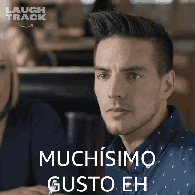 a man in a blue shirt has the word muchisimo on his face