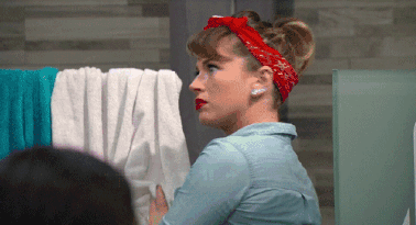 a woman wearing a red bandana is standing in front of a stack of towels