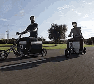 two men are riding motorcycles with coolers attached to them .