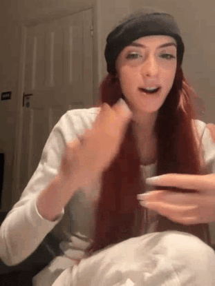 a woman with long red hair wearing a black hat