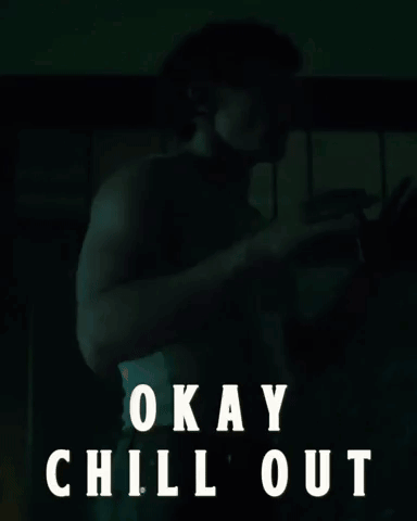 A man sits in a dark scene under the caption “OKAY CHILL OUT.”