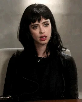 Jessica Jones rolls her eyes with a tired, annoyed expression.