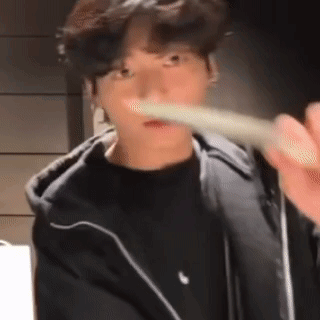 A man points a white utensil or object toward the camera with a playful expression.