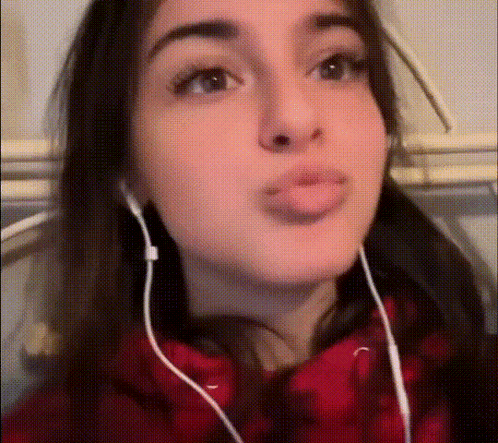 a close up of a woman wearing headphones and making a funny face
