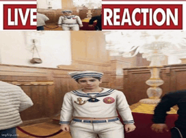 a man in a sailor outfit stands in front of a sign that says " live reaction "