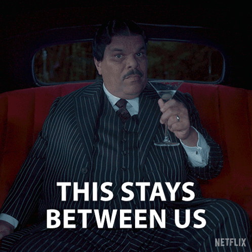 a man in a suit and tie is holding a martini and says this stays between us