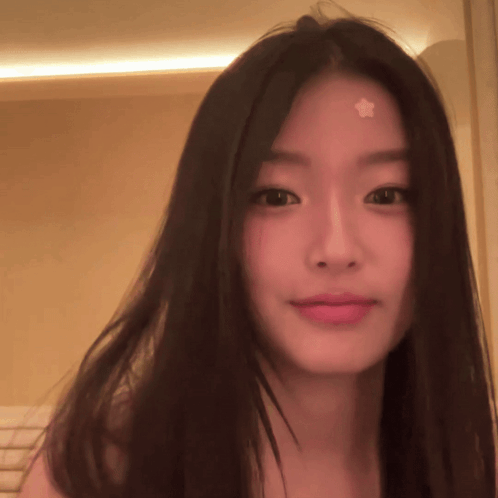 A young woman gives the camera a restrained, annoyed smile.