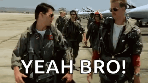 Two flight-suited pilots stand together, captioned “YEAH BRO!”