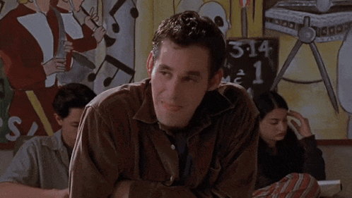 a man in a classroom says okay let 's not all rush to disagree