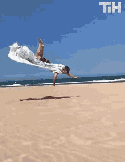 a person is laying on a sandy beach with the letters th on the bottom