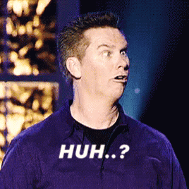 Brian Regan makes a confused wide-eyed face onstage, captioned “HUH?”.