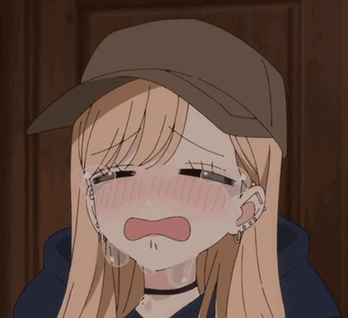 A blushing anime girl in a cap cries with her eyes shut.