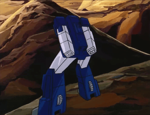 a blue and white robot is standing on a rocky hill