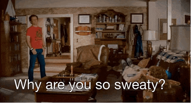 a man standing in a living room with the words " why are you so sweaty " on the bottom