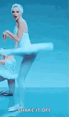 a couple of ballerinas are dancing on a blue background and one of them is holding another ballerina 's hand .