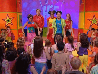 a group of children are dancing in front of a sign that says ' jr. ' on it