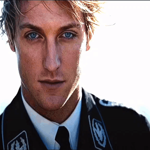 a close up of a man 's face wearing a black jacket