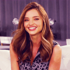 Miranda Kerr smiles brightly and gives a playful wink.