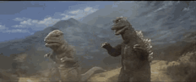 two dinosaurs are standing next to each other on top of a dirt hill .