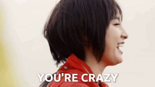 a woman in a red jacket is laughing with the words you 're crazy above her