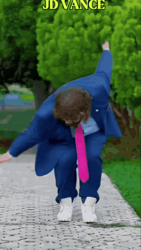 A suited person dances dramatically in front of hedges with “JD VANCE” text.