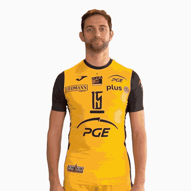 a man wearing a yellow pge jersey holds up his hand