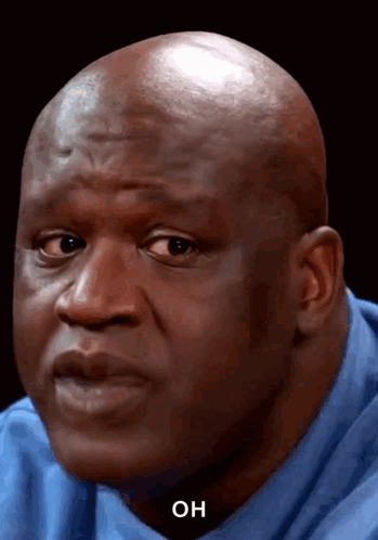Shaquille O’Neal looks sideways with a skeptical surprised expression.