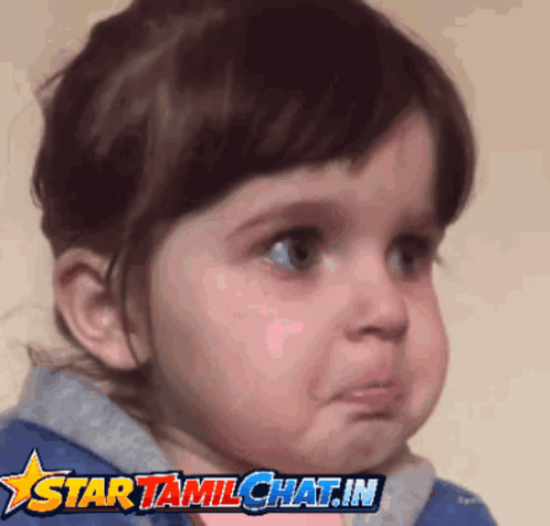 A young child cries with tears on their cheeks.