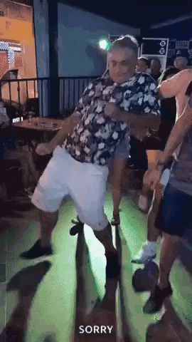An older man dances outside a bar while people watch.