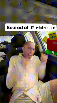 a man is sitting in the back seat of a car with a sign that says scared of weird strict dad .