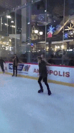 a man is ice skating in front of a sign that says ' apollos ' on it