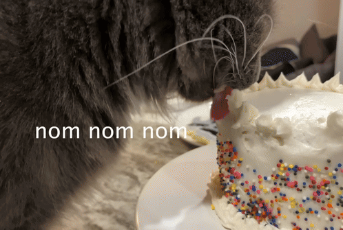 a cat is sniffing a cake with the words nom nom nom written above it
