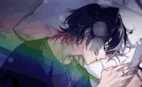 a man is sleeping in a bed with headphones on and looking at his phone .