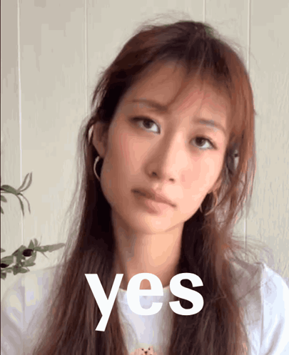 A woman looks at the camera with a restrained “yes” expression.