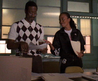 a man in a plaid vest is talking to a woman