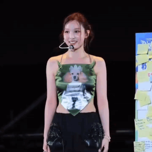 a woman wearing a green top with a picture of a poodle on it