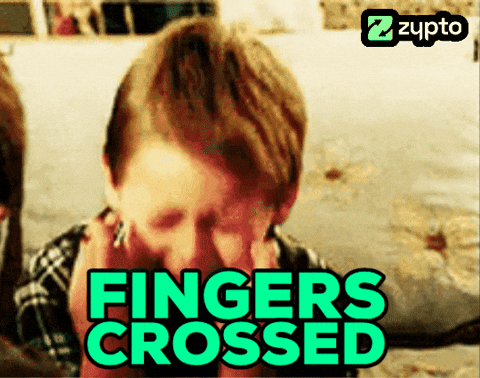 A child crosses their fingers beneath bold turquoise text reading “FINGERS CROSSED.”