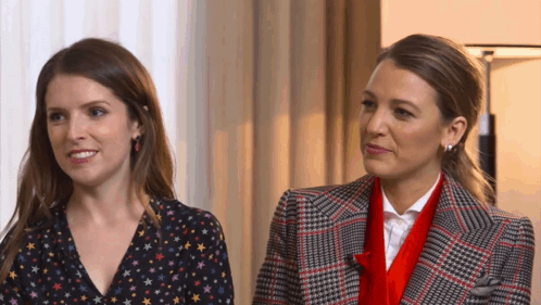 two women are standing next to each other and one is wearing a plaid jacket