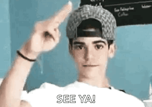 a young man wearing a baseball cap is pointing up with his finger and saying `` see ya '' .