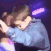 A blurry dancer performs under vivid purple club lighting.
