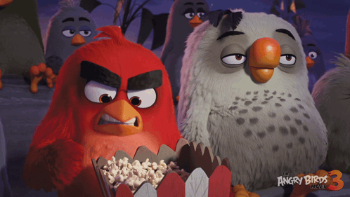 Red from The Angry Birds Movie glares while holding popcorn.