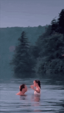a man and woman are swimming in a lake
